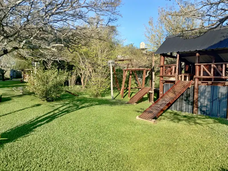 Vista panorámica del área de juegos infantiles y parque verde
