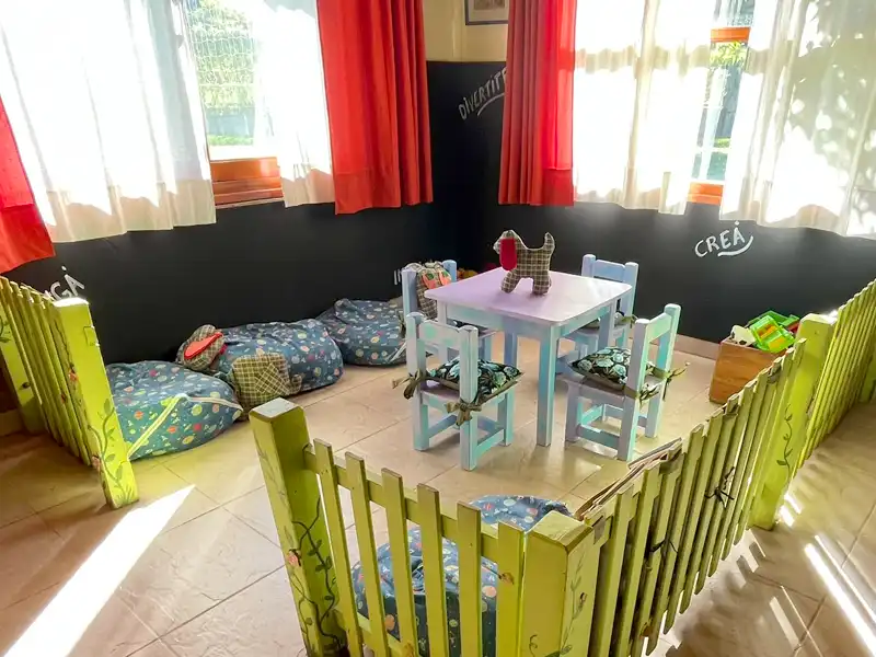 Mesita didáctica con sillas infantiles, juguetes y pizarras